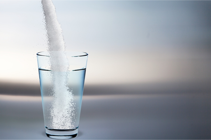 Sugar being poured into water