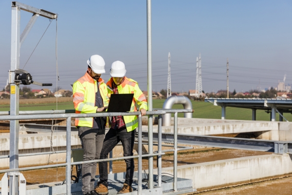 Water treatment plant workers consulting a checklist
