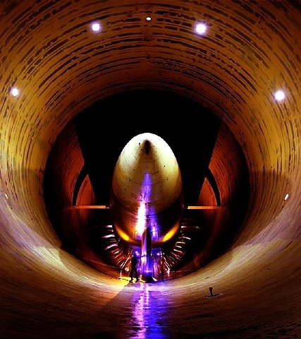 Shown is a colour photograph of a person in a  huge cylindrical room.