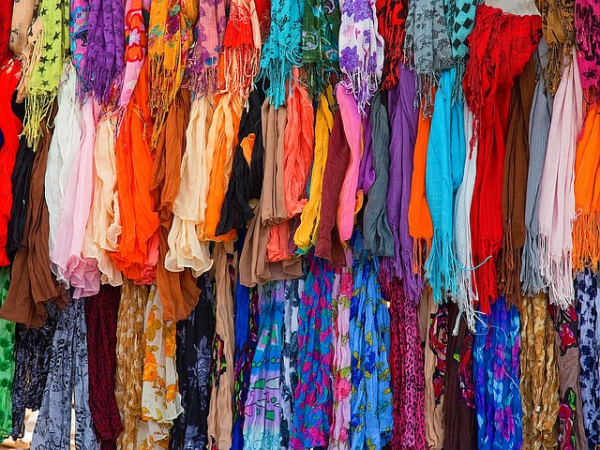 Shown is a colour photograph filled with dozens of colourful scarves.