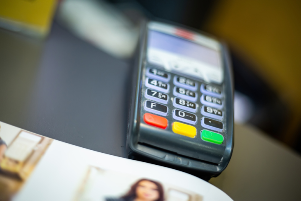 Shown is a colour photograph of a card payment terminal on a counter.