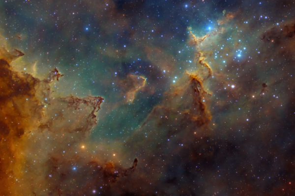 Shown is a colour image of glowing gas, dust and stars in space.