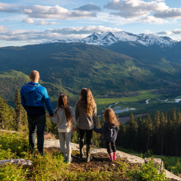 Family standing in front of mountain range