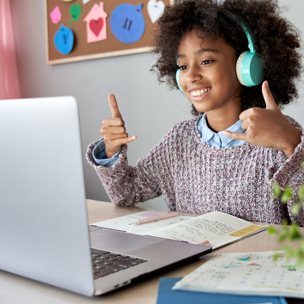 Girl with headphones on smiling at laptop